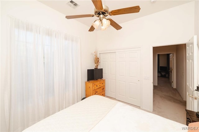 carpeted bedroom with a ceiling fan, a closet, and visible vents