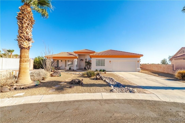 mediterranean / spanish house featuring driveway, a garage, a tile roof, fence, and stucco siding