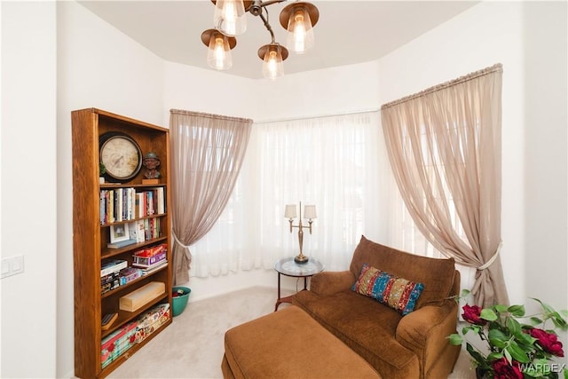 sitting room featuring carpet and an inviting chandelier