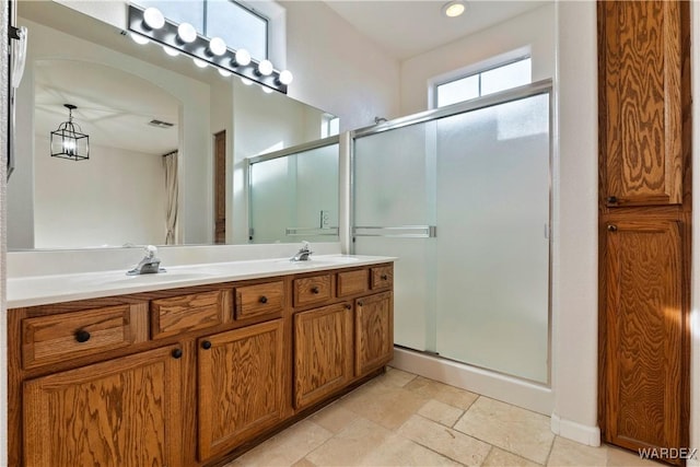 bathroom with double vanity, a stall shower, and a sink