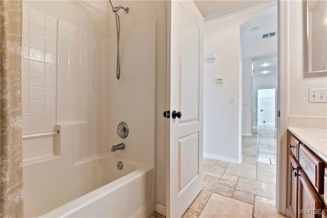 full bath with visible vents, vanity, baseboards, shower / bath combination with curtain, and stone tile flooring