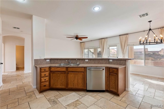 kitchen with stone tile floors, a sink, visible vents, and brown cabinets