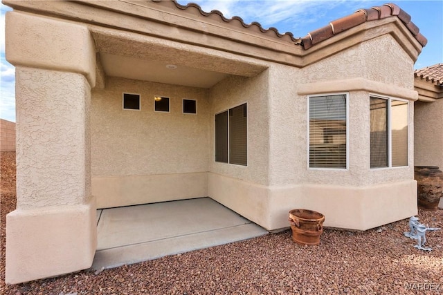 exterior space with a tiled roof and stucco siding