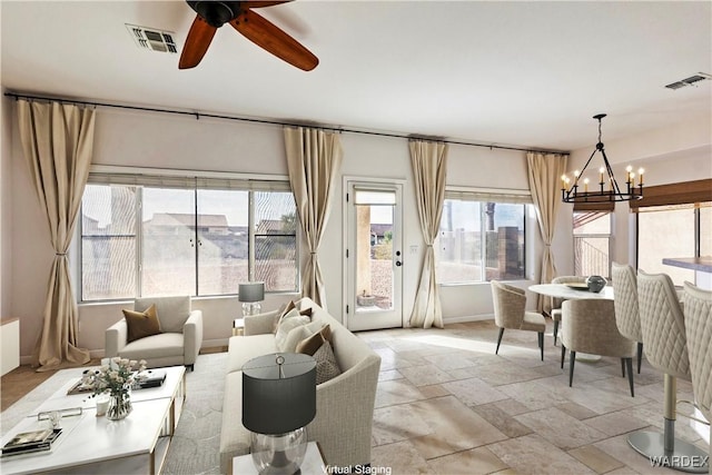 living room featuring a healthy amount of sunlight, visible vents, and stone tile flooring