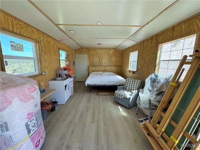 bedroom with wooden walls and light wood-type flooring