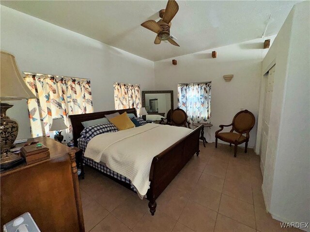 bedroom featuring light tile patterned floors, vaulted ceiling, and a ceiling fan