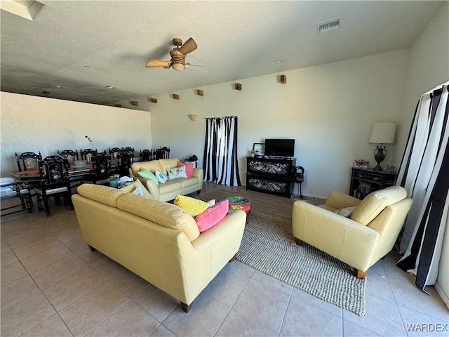living room featuring ceiling fan, visible vents, and light tile patterned floors