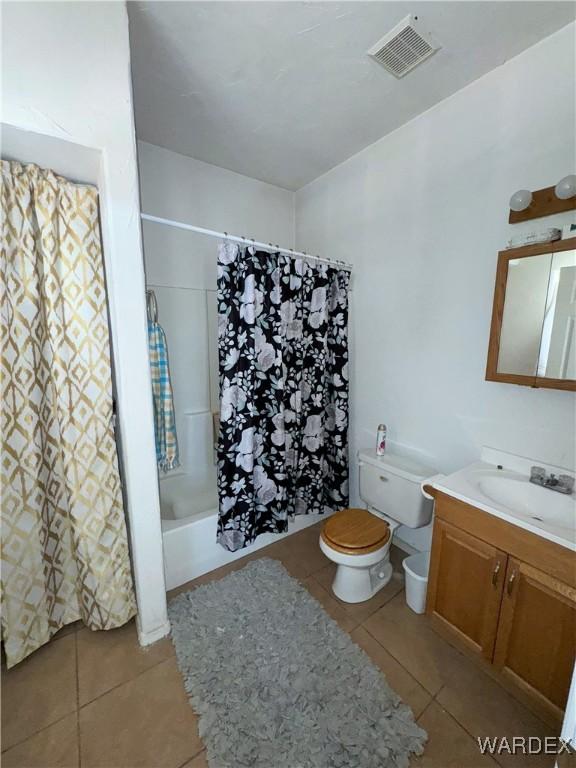 full bathroom featuring vanity, visible vents, toilet, tile patterned floors, and shower / bath combo with shower curtain