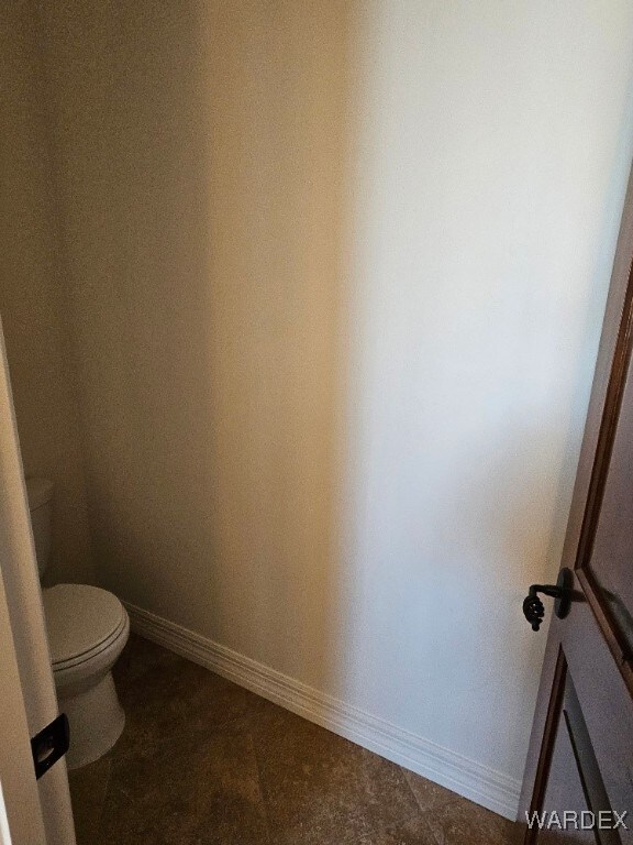 bathroom featuring toilet and baseboards