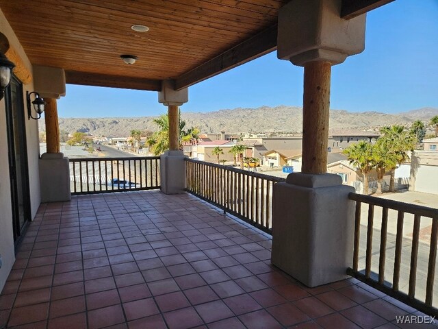 view of patio / terrace with a balcony, a residential view, and a mountain view