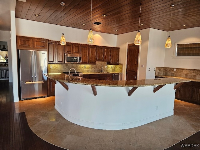 kitchen featuring appliances with stainless steel finishes, wooden ceiling, hanging light fixtures, and a kitchen bar