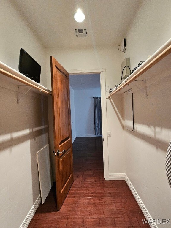 spacious closet featuring visible vents and dark wood finished floors