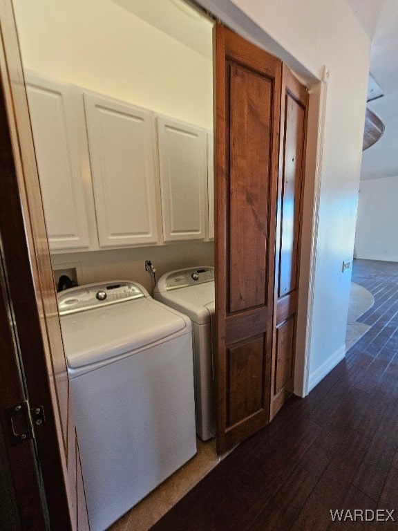 laundry area with cabinet space, baseboards, separate washer and dryer, and dark wood finished floors