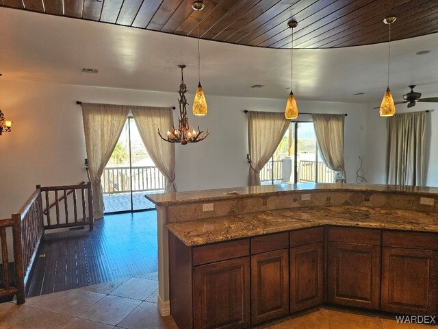 kitchen featuring stone countertops, visible vents, wooden ceiling, decorative light fixtures, and a notable chandelier