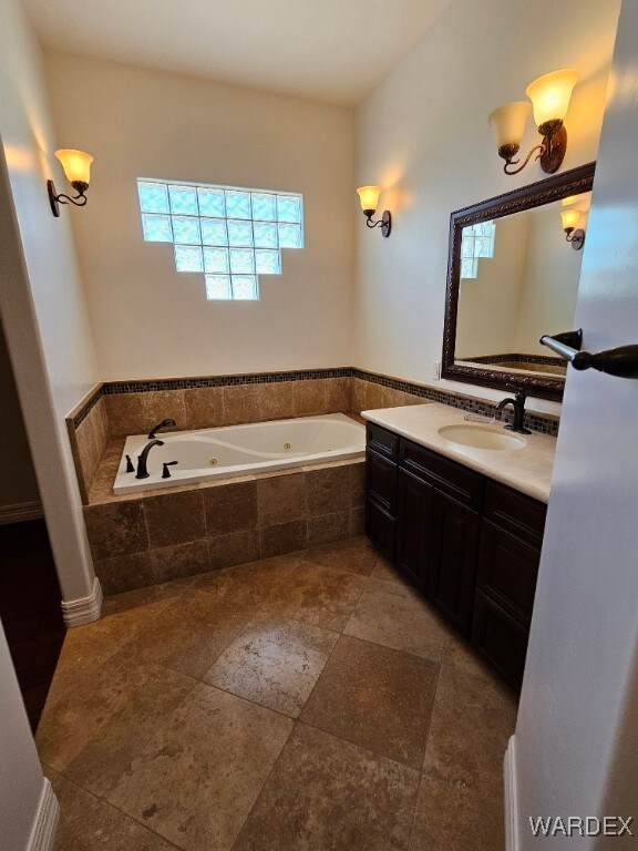 full bath with a tub with jets and vanity