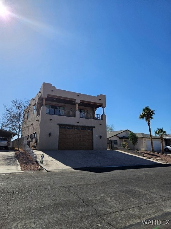 view of front of property with a garage, concrete driveway, and stucco siding