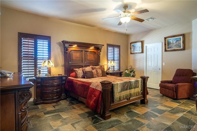 bedroom featuring stone finish flooring, visible vents, and ceiling fan