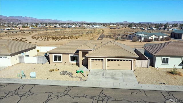 single story home featuring driveway, a tile roof, a gate, fence, and a mountain view