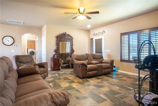 living area with washer / dryer, stone finish floor, visible vents, and baseboards