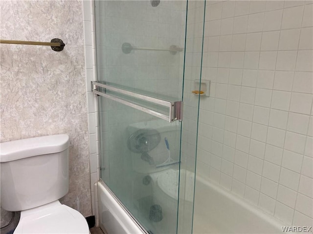 bathroom featuring shower / bath combination with glass door and toilet