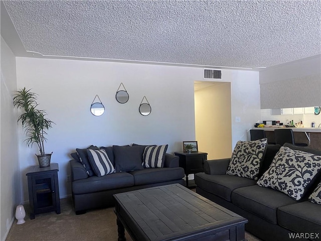 living room with carpet, visible vents, and a textured ceiling