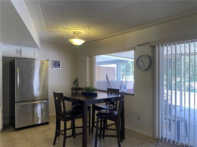 dining space with baseboards and a textured ceiling