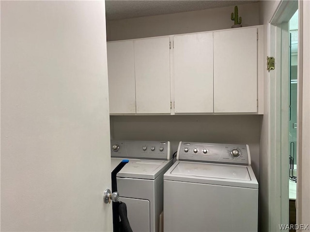 washroom featuring washer and dryer and cabinet space