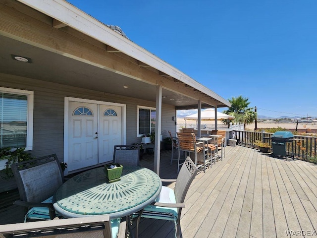 wooden terrace with grilling area and outdoor dining area