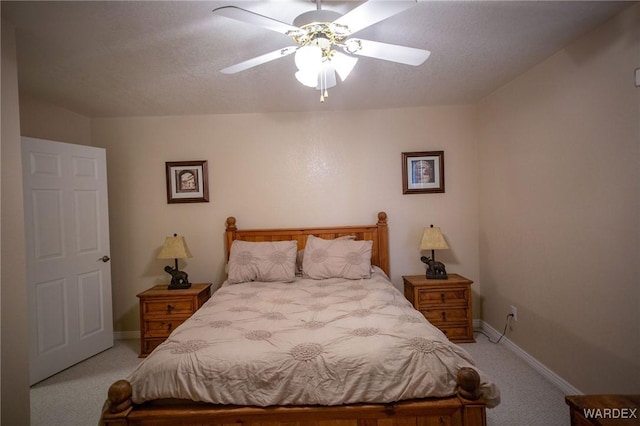 bedroom featuring light colored carpet, ceiling fan, a textured ceiling, and baseboards