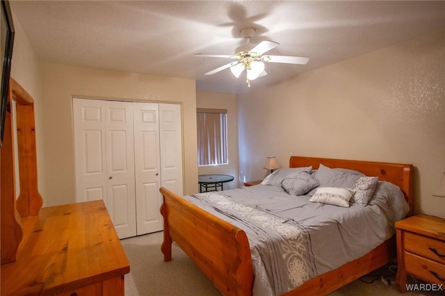 bedroom featuring ceiling fan, a closet, and light colored carpet