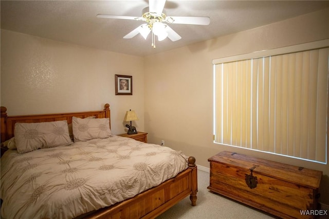 bedroom featuring light carpet and a ceiling fan