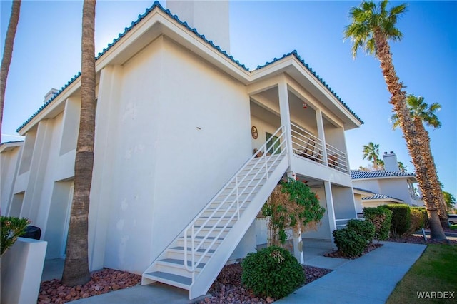 exterior space featuring stairway and stucco siding