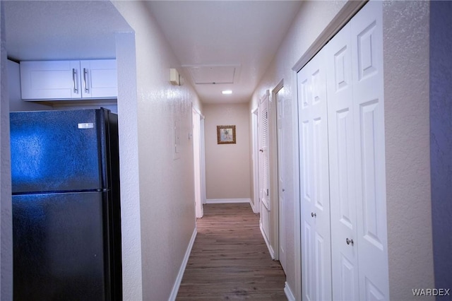 hallway with baseboards and wood finished floors