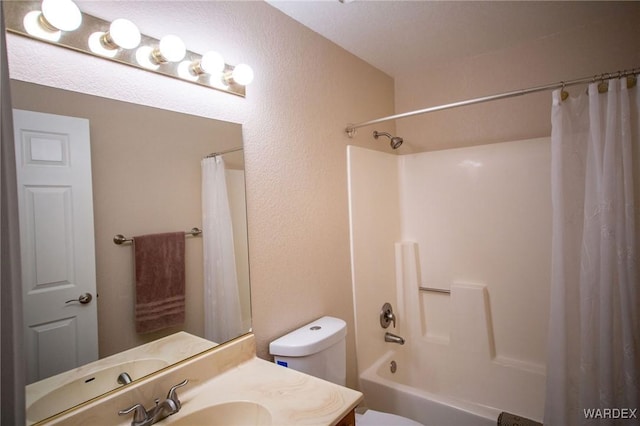 full bath with shower / bathtub combination with curtain, a textured wall, vanity, and toilet