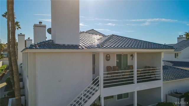 back of property featuring a chimney and stucco siding