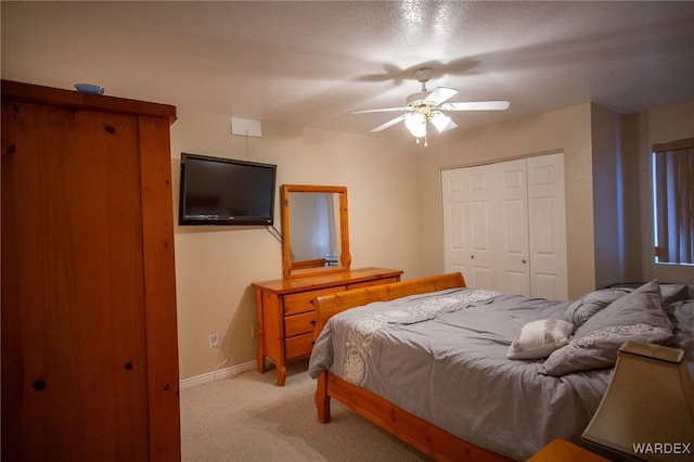 bedroom featuring ceiling fan, baseboards, a closet, and light colored carpet