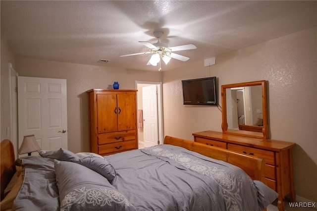 bedroom featuring ceiling fan and a textured wall