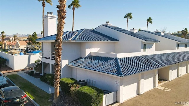 exterior space with a tile roof, a residential view, cooling unit, and stucco siding