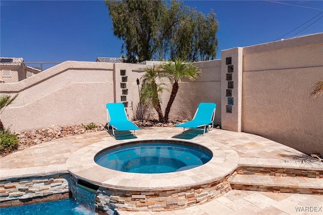 view of swimming pool featuring a patio area, a fenced backyard, and an in ground hot tub