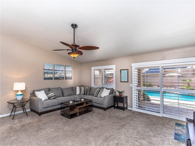 living room with light carpet, baseboards, vaulted ceiling, and ceiling fan