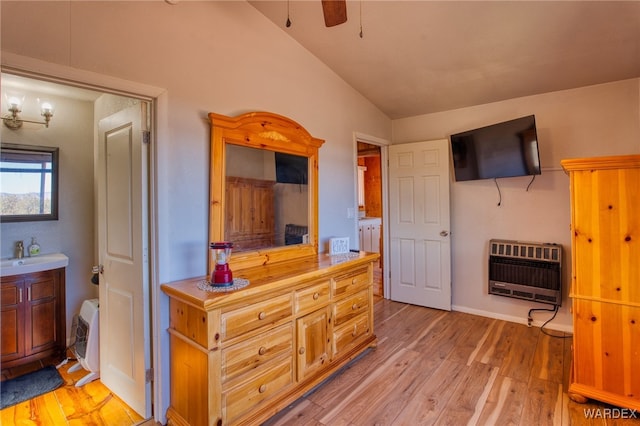 bathroom with lofted ceiling, ceiling fan, wood finished floors, heating unit, and vanity