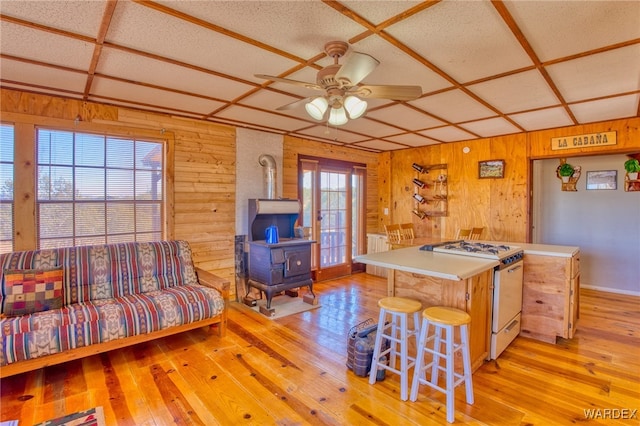 kitchen featuring a wood stove, a healthy amount of sunlight, white range with gas cooktop, and coffered ceiling