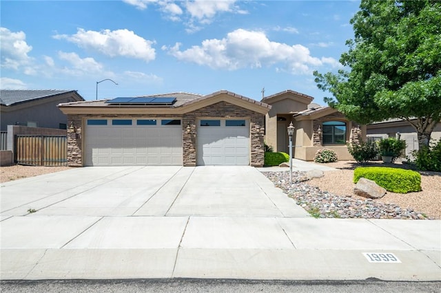 1999 Alan Ladd Dr, Kingman, AZ 86409 - ranch-style house with an attached garage, solar panels, concrete driveway, stone siding, and fence