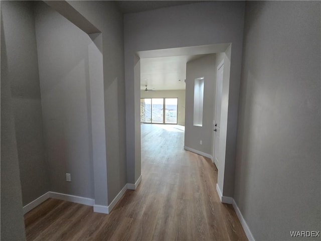 hall featuring wood finished floors and baseboards