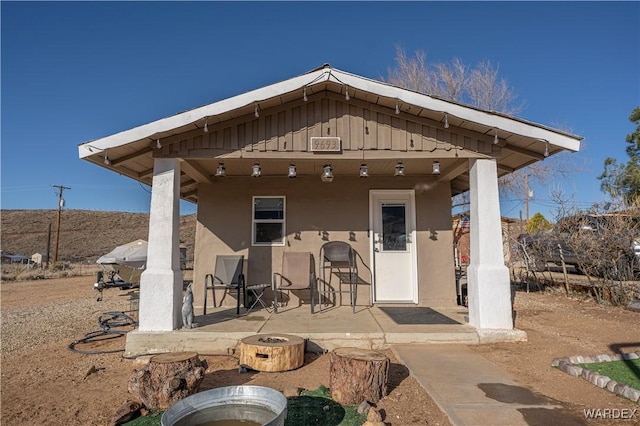 rear view of property with a patio area, an outdoor fire pit, and stucco siding