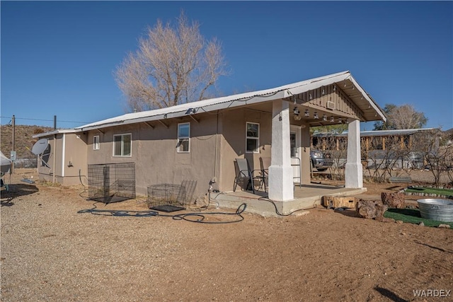 rear view of house featuring a patio area and stucco siding