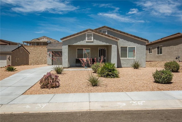 2635 Bear Mountain Loop, Bullhead City, AZ 86442 - ranch-style home featuring concrete driveway, a porch, stucco siding, an attached garage, and a tiled roof