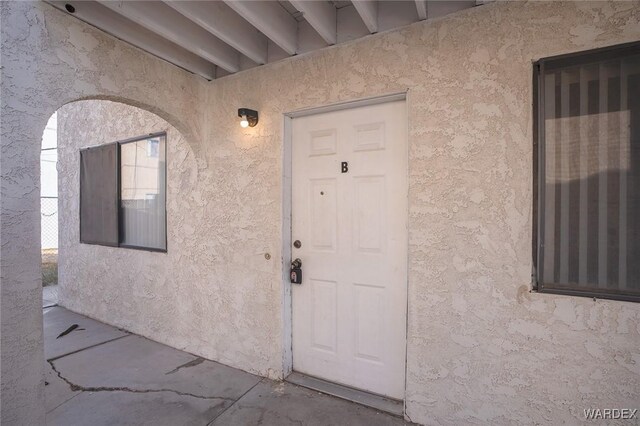 entrance to property with stucco siding