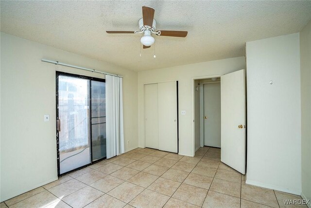 unfurnished bedroom with light tile patterned floors, ceiling fan, access to outside, a textured ceiling, and a closet