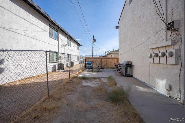 view of yard with cooling unit, a patio area, and fence